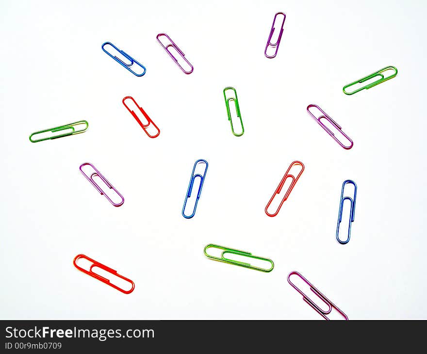 Scattered solored paper clips on white. Scattered solored paper clips on white.