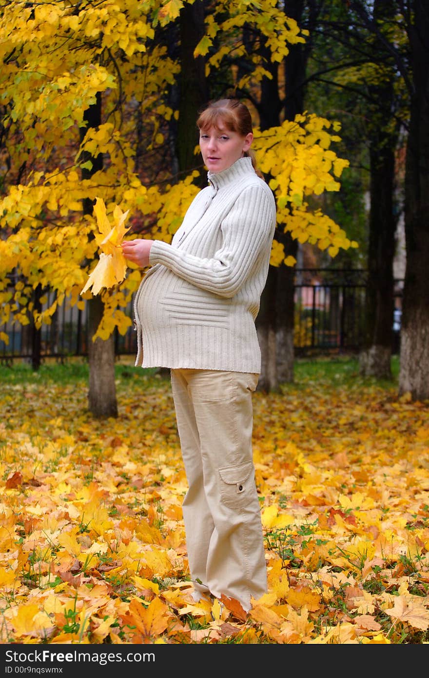 Pregnant woman in autumn park hold maple leaf #2