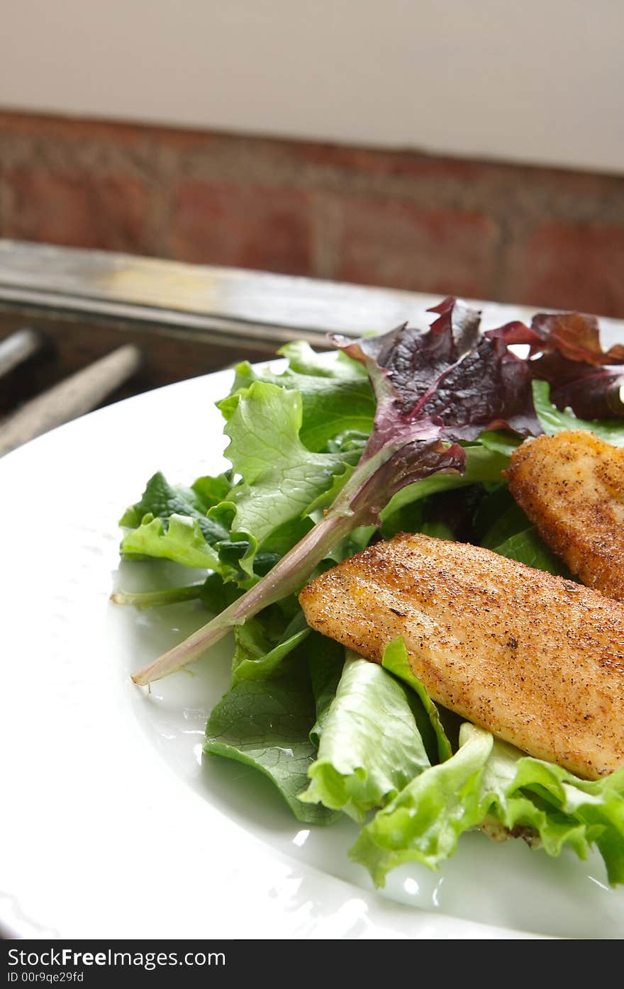 Seasoned Tilapia on bed of mixed salad