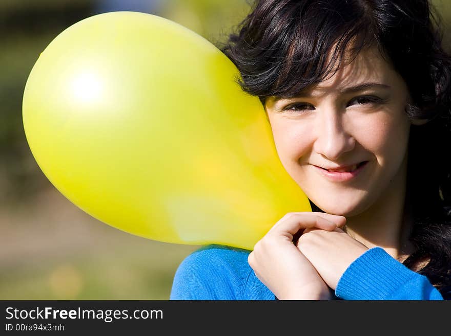 Cute girl with yellow colored balloon in the park