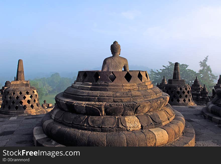 Indonesia, java, Borobudur: a beautifull stone seat buddha in meditation facing to the sunrise at the most famous asiatic temple, the bigest buddhist temple from the first millenium in the world. Indonesia, java, Borobudur: a beautifull stone seat buddha in meditation facing to the sunrise at the most famous asiatic temple, the bigest buddhist temple from the first millenium in the world