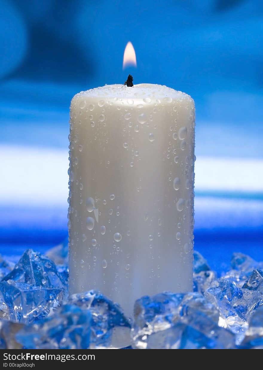 Candle with ice on blue background