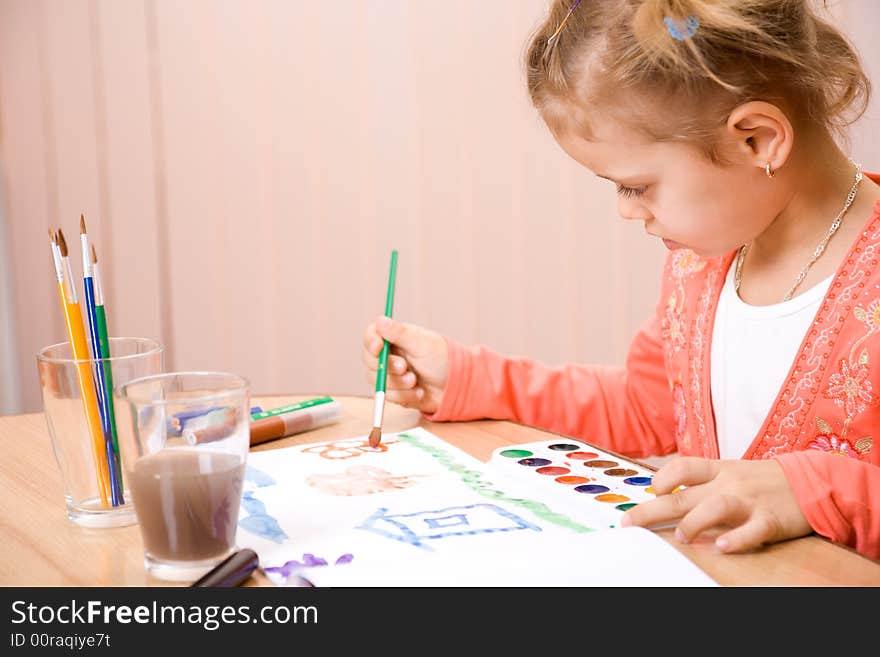 Pretty caucasian child watercolor paint . Close-up