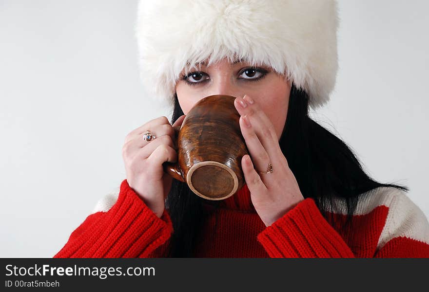 Young girl in fluffy hat with hot drink. Young girl in fluffy hat with hot drink