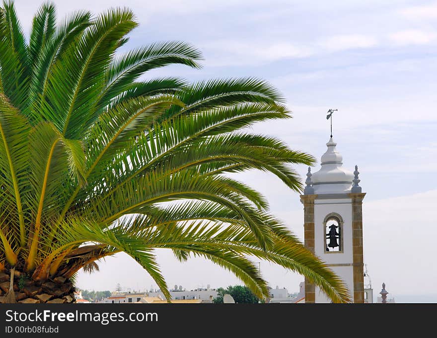 Portugal, area of Algarve, Albufeira: blue sky, palm trees and a white church; typical architecture. Portugal, area of Algarve, Albufeira: blue sky, palm trees and a white church; typical architecture