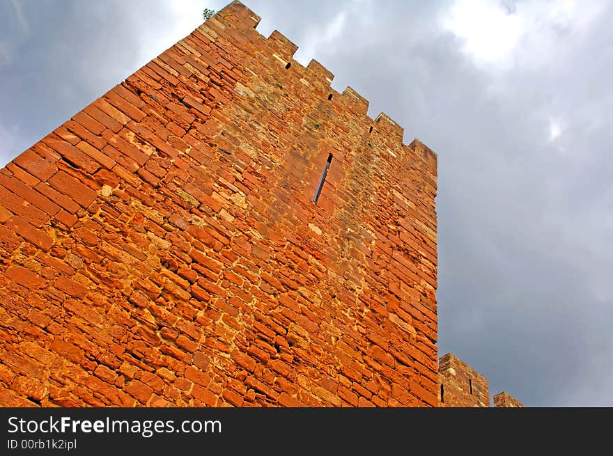 Portugal, area of Algarve, Silves: typical architecture, castle. Blue sky and an ancient red stone castle. Portugal, area of Algarve, Silves: typical architecture, castle. Blue sky and an ancient red stone castle