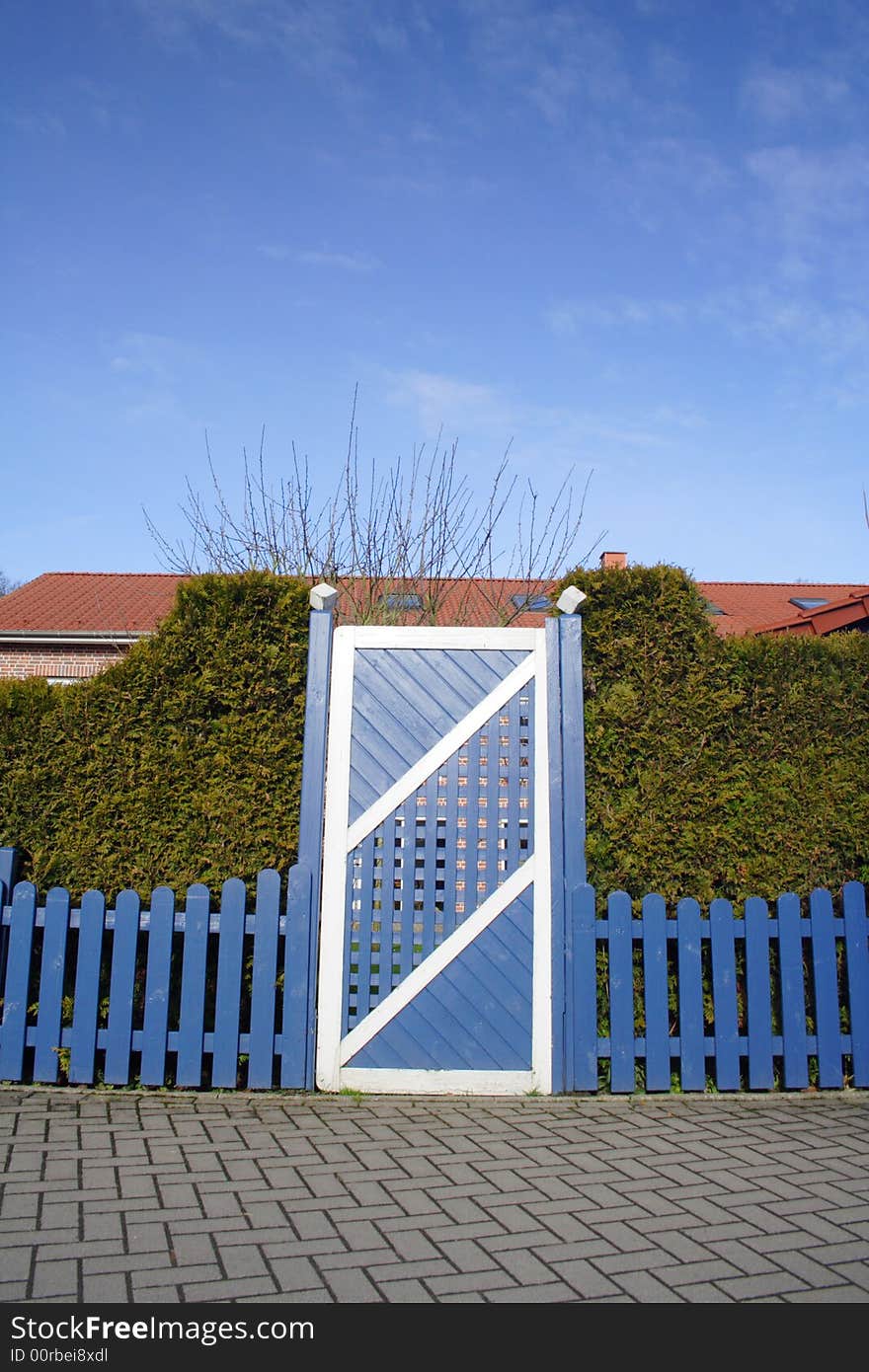 A blue and white gate with blue fance and blue sky