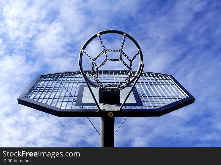 Basketball hoop and backboard set against a blue sky