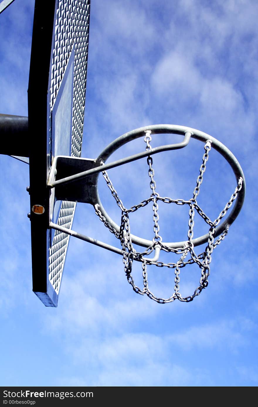 Basketball hoop and backboard set against a blue sky