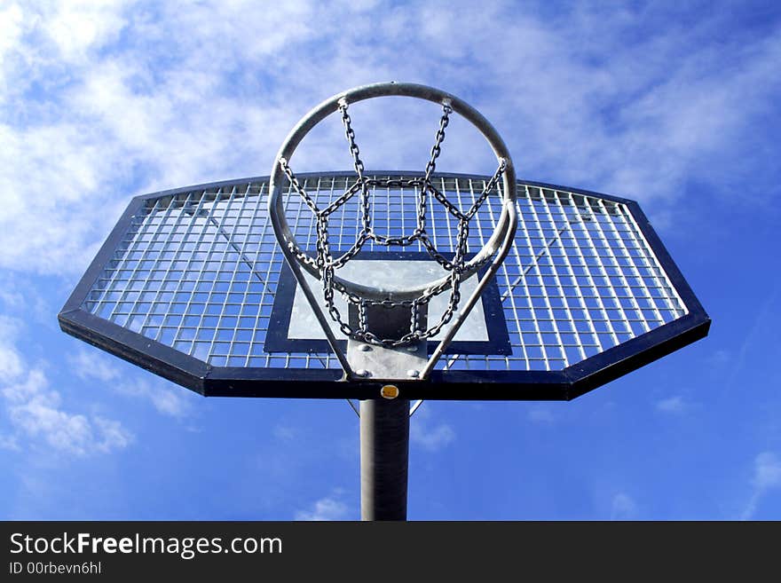 Basketball hoop and backboard set against a blue sky