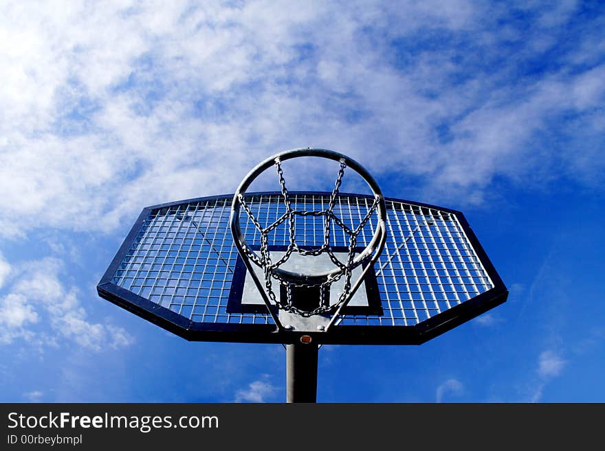 Basketball hoop and backboard set against a blue sky