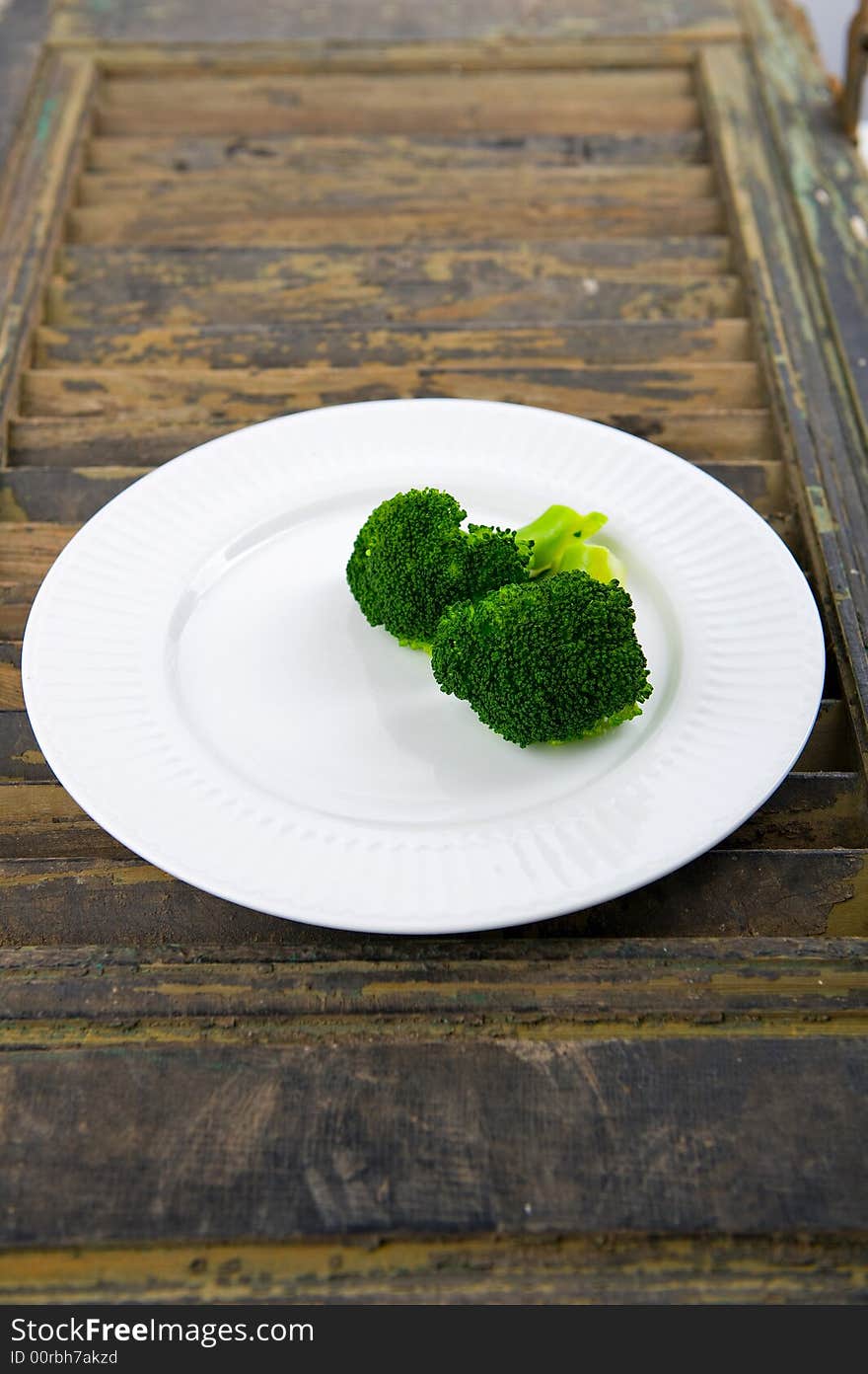 Green steamed broccoli on a white plate