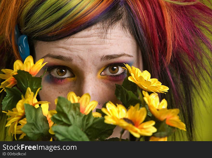 Pretty young woman peeks out from behind plastic flowers. Pretty young woman peeks out from behind plastic flowers.