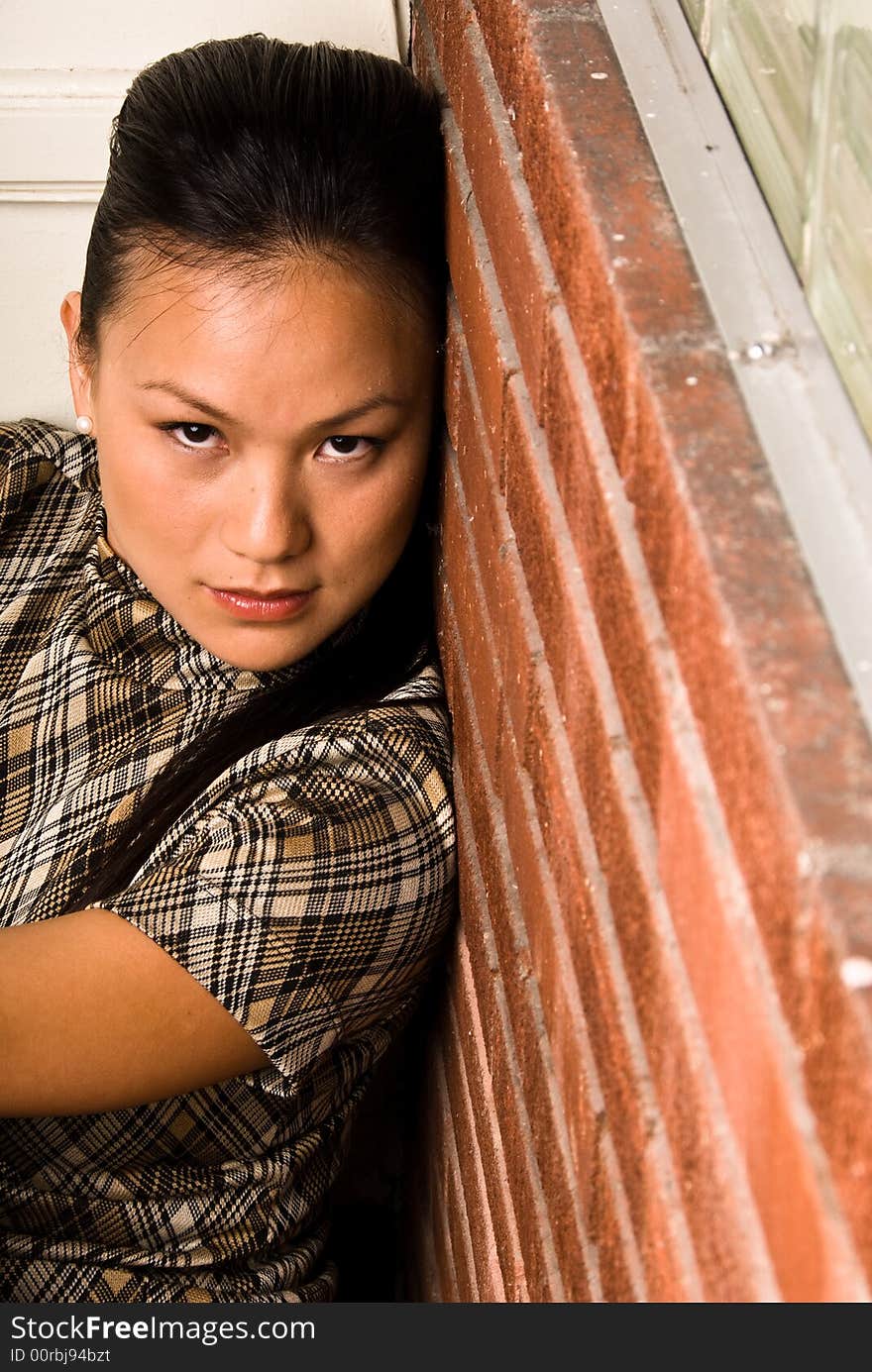 Female model pressing her face to the wall to get the shot. Female model pressing her face to the wall to get the shot