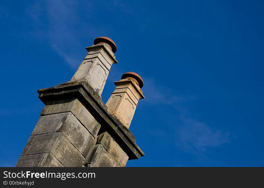 Old british chimney on a sunny day with clear blue sky.