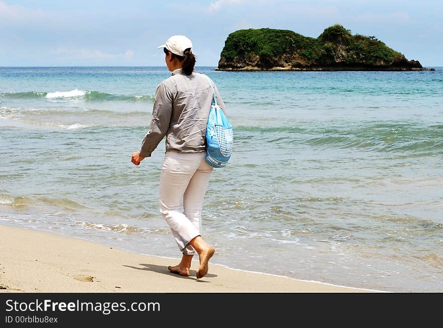 The girl is walking along Puerto Viejo shore, Costa Rica. The girl is walking along Puerto Viejo shore, Costa Rica.