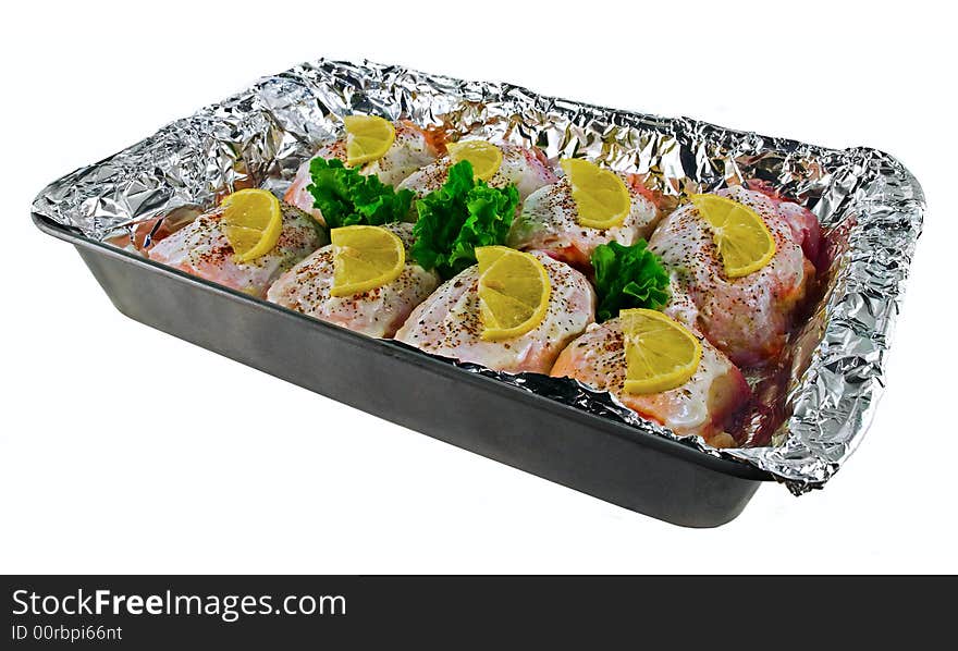 Seasoned chicken breasts with lemon slices in the tray. Seasoned chicken breasts with lemon slices in the tray