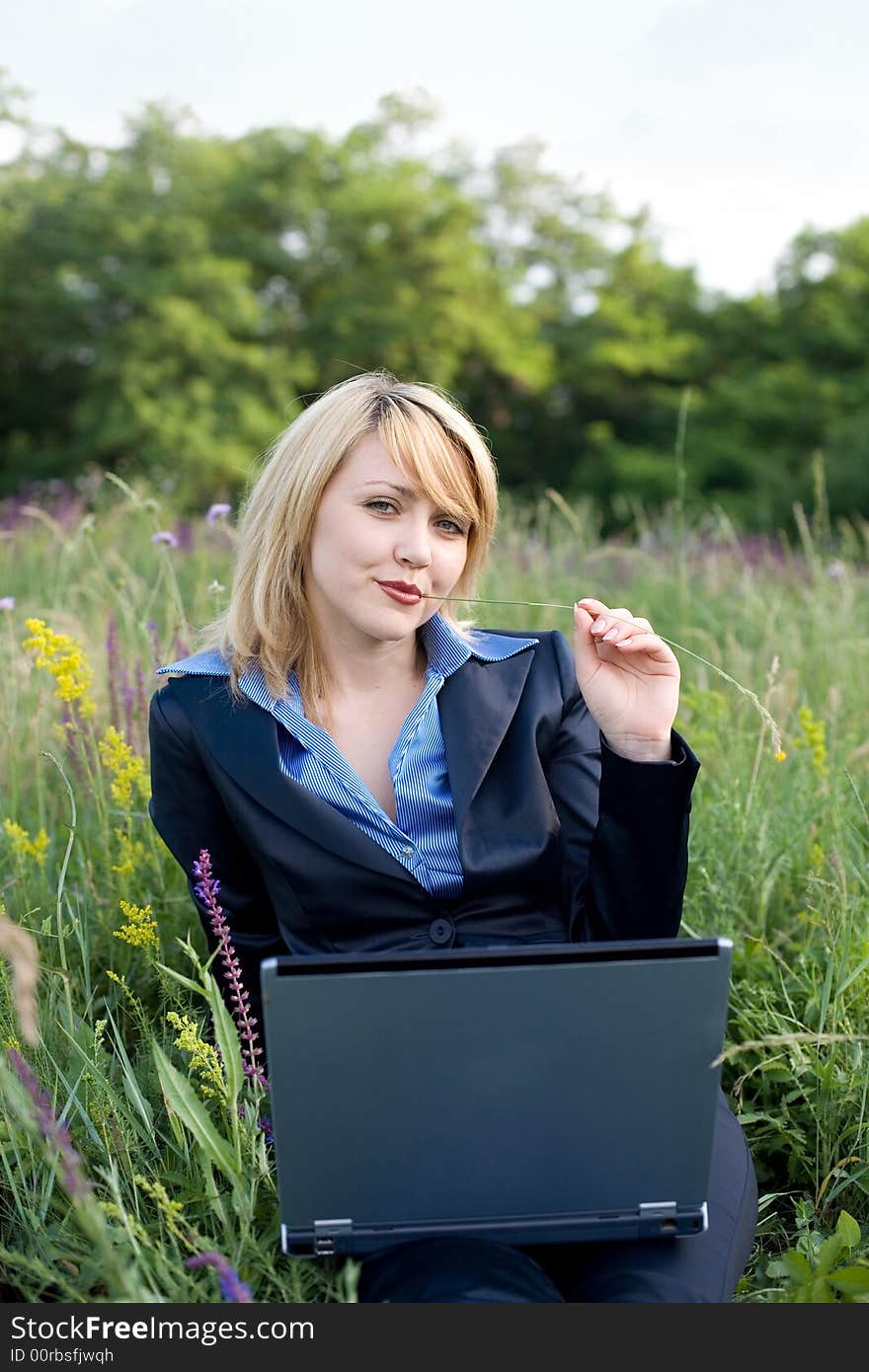 Contented businesswoman sitting on grass