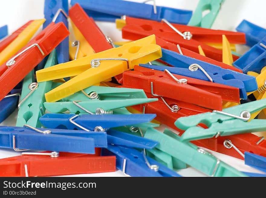 A pile of colorful cloths clips on a white background.