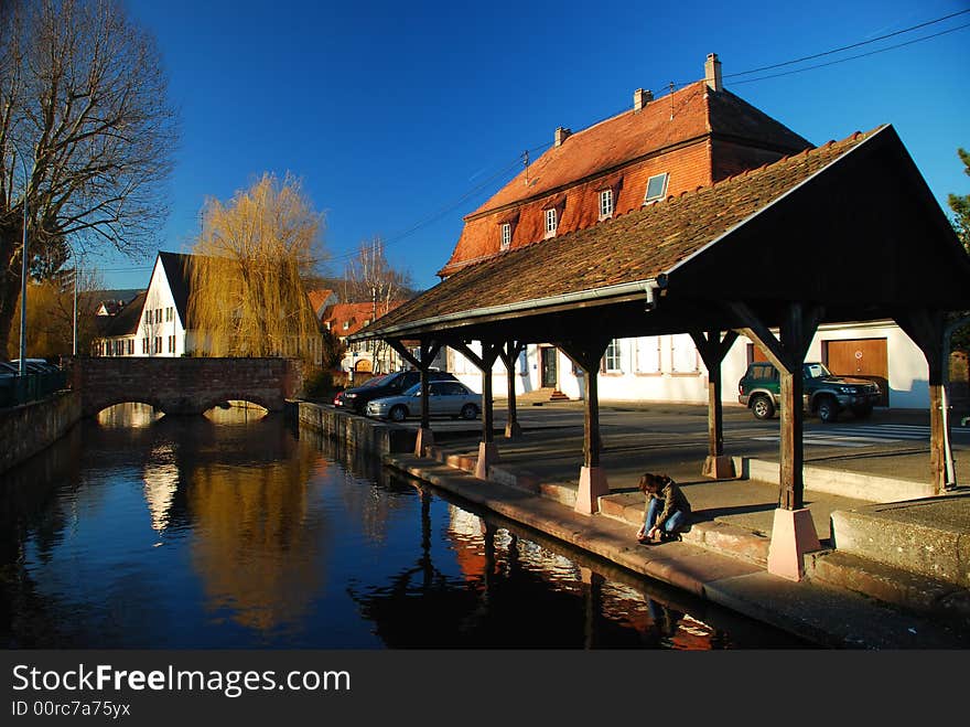 Old wash house in a city with a girl sitting