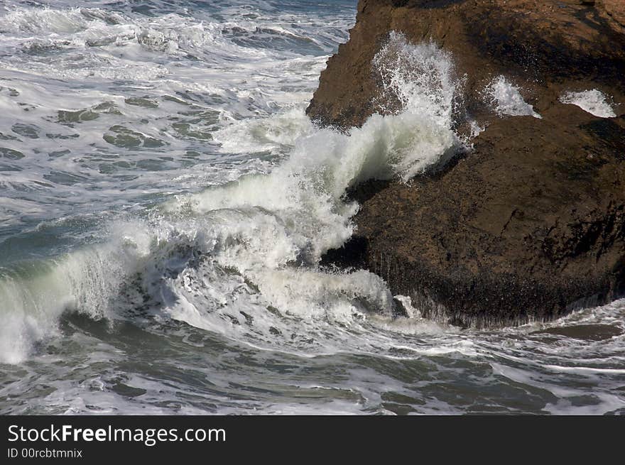 Pacific Ocean Waves break against the rocks.