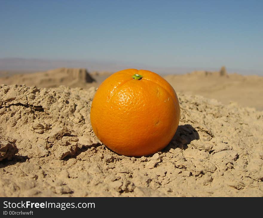 an orange in the desert alone