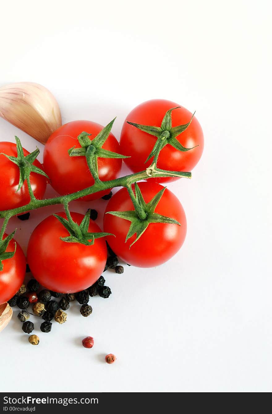 Close up of fresh tomatoes, garlic and pepper over white