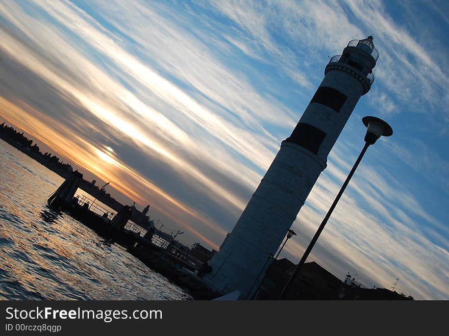 The lighthouse of the isle of Murano at sunset, near Venice in Italy