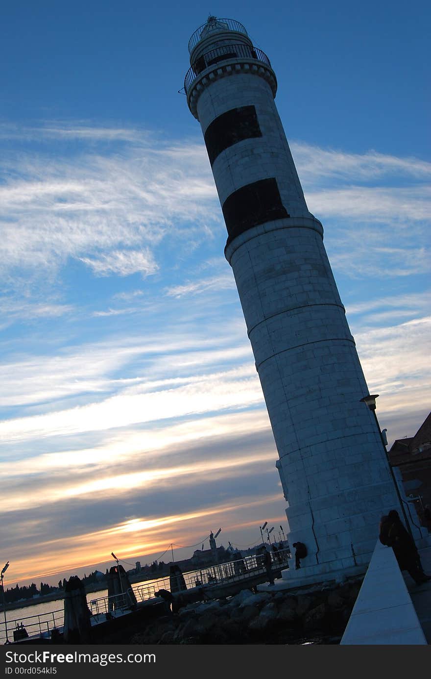 The lighthouse of the isle of Murano at sunset, near Venice in Italy