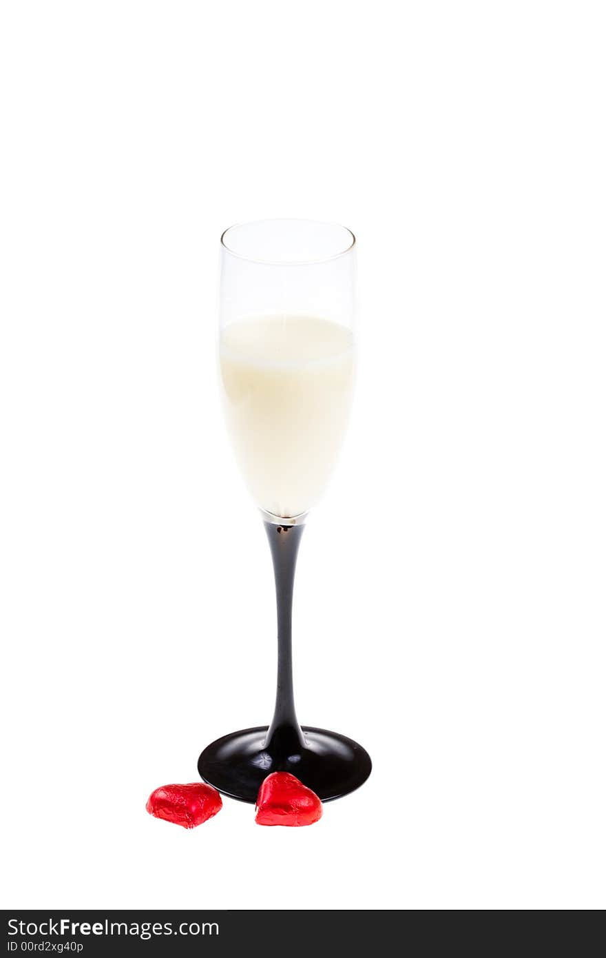 Glass with liquor and two red hearts  on a white background (isolated). Glass with liquor and two red hearts  on a white background (isolated)