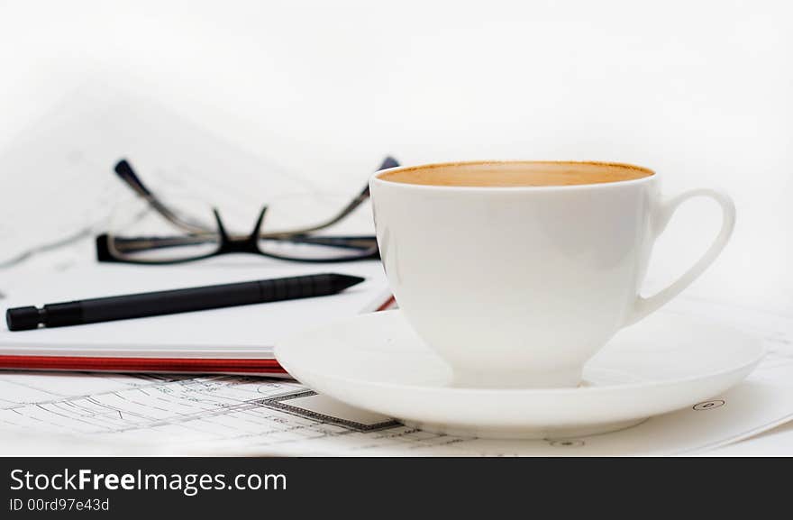 Cup of coffee with glasses an notepad.