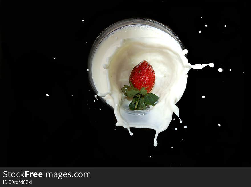 A strawberry falling into a bowl of milk with a splash. A strawberry falling into a bowl of milk with a splash.