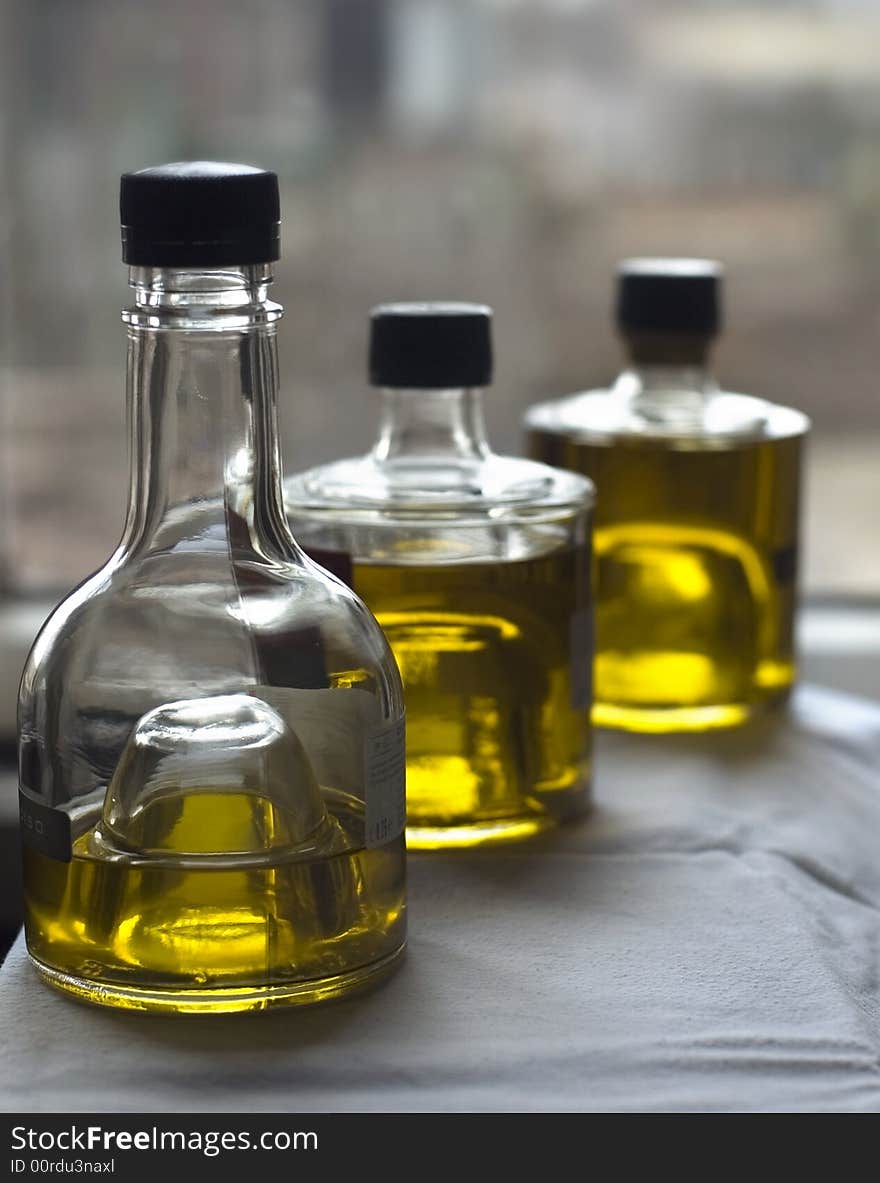 Three bottles of olive oil at the window