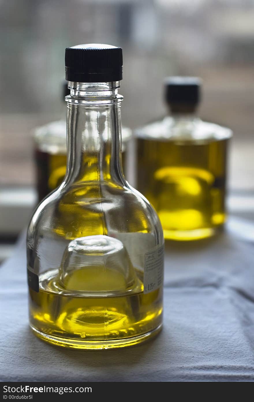 Three bottles of olive oil at the window