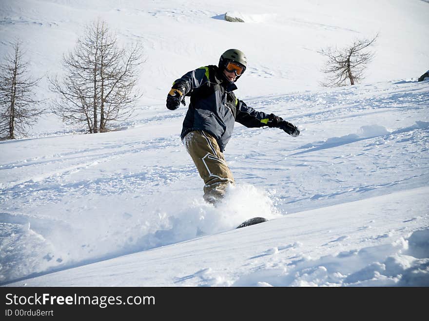 The snowboarder riding on a virgin soil (extreme sport)