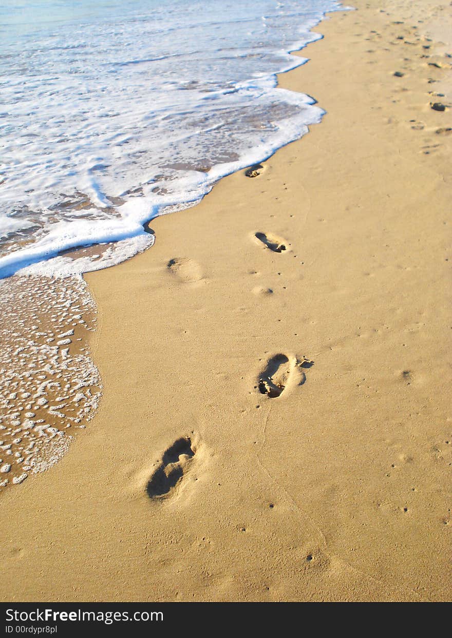 Footprints on sand by the sea surf. Footprints on sand by the sea surf