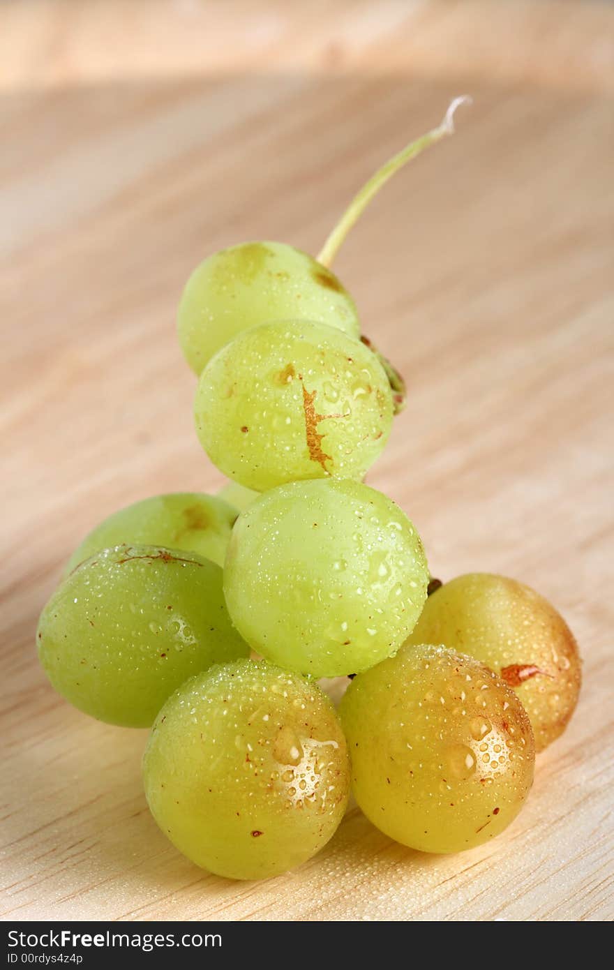 Bunch of green grape on wood with water drops. shallow dof