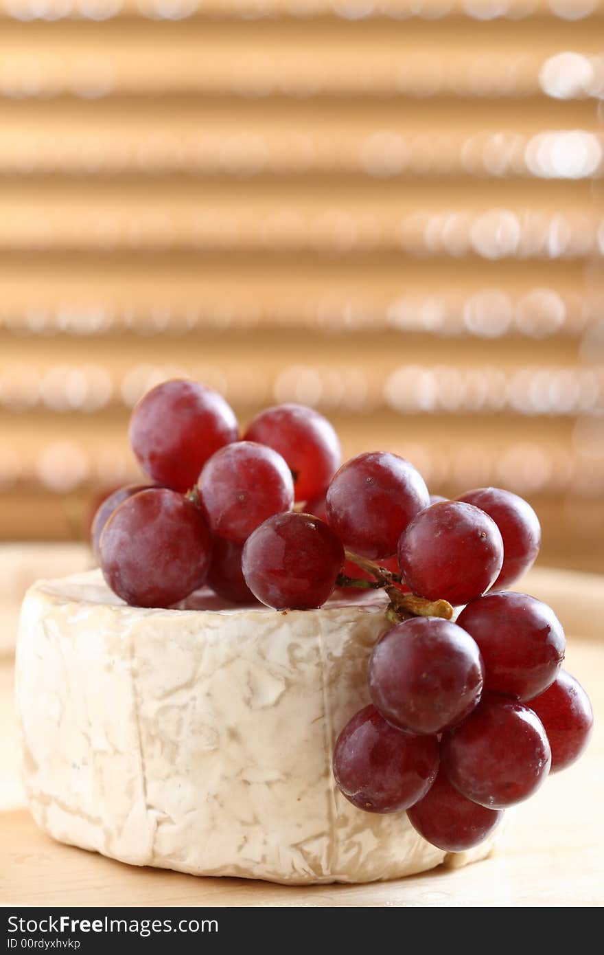 Red grape and soft cheese on wood, shallow dof.