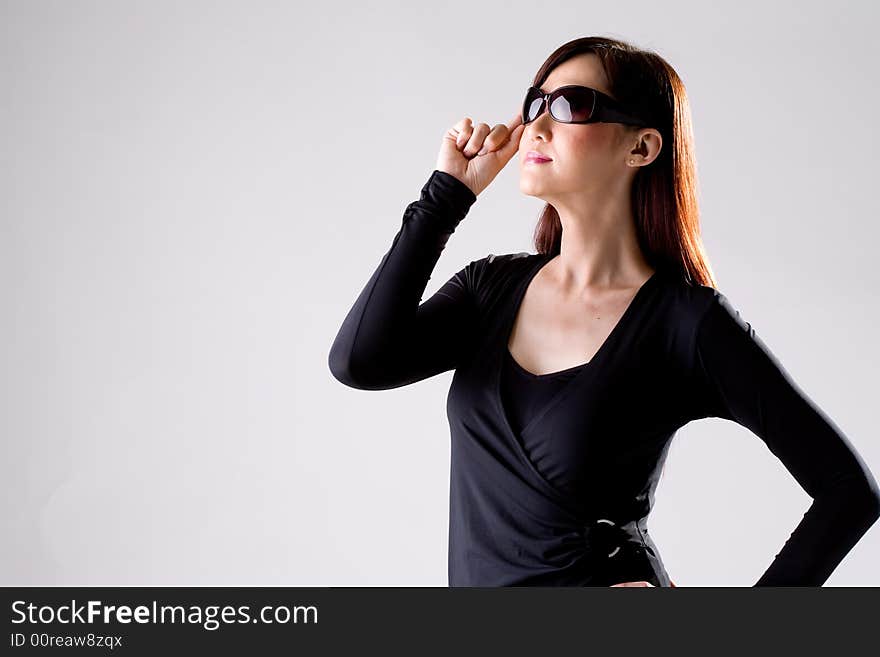 Woman in dark navy blue top wearing a pair of sunglasses. Woman in dark navy blue top wearing a pair of sunglasses