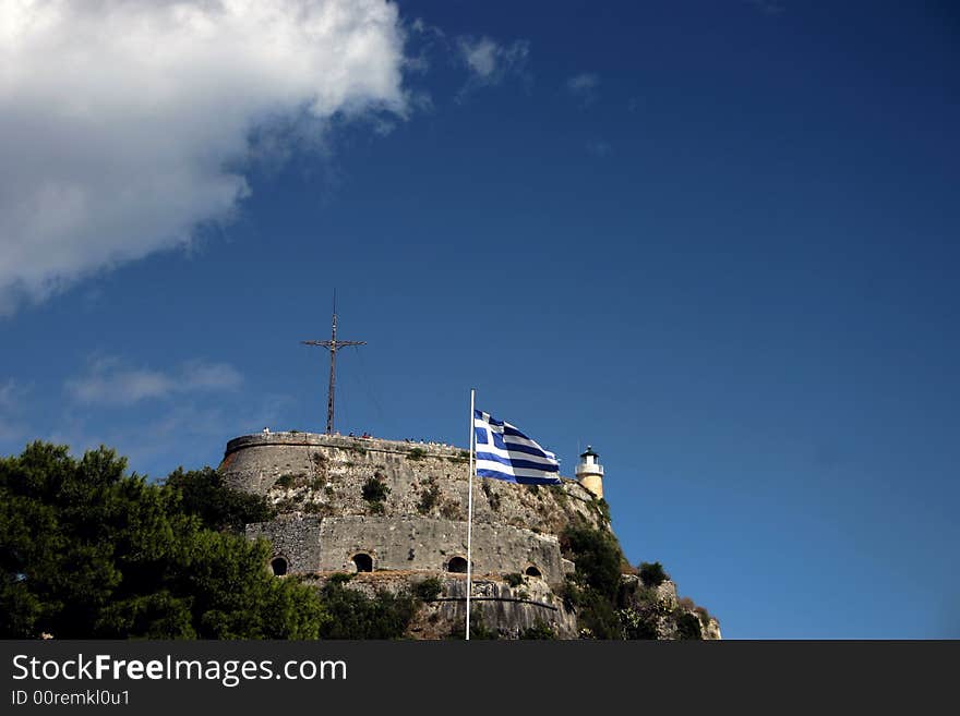 Greek flag in front of old fortress in Corfu town, Greece