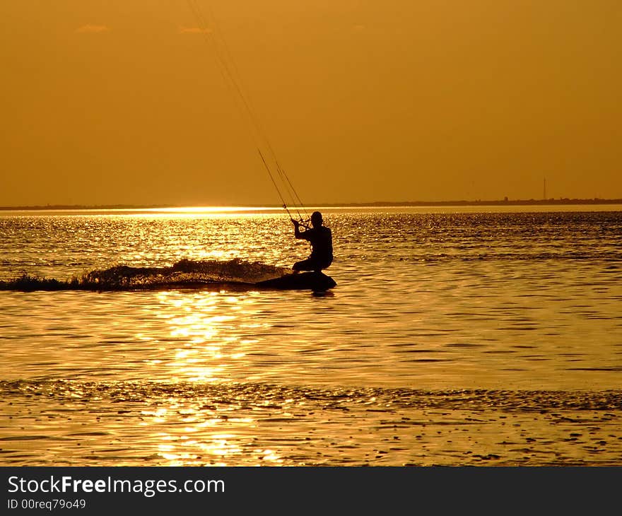 Silhouette of a kite-surf on waves of a gulf on a sunset 1. Silhouette of a kite-surf on waves of a gulf on a sunset 1