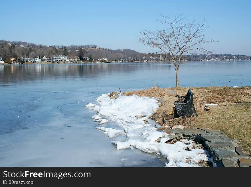 Old empty bench on a frozen lake