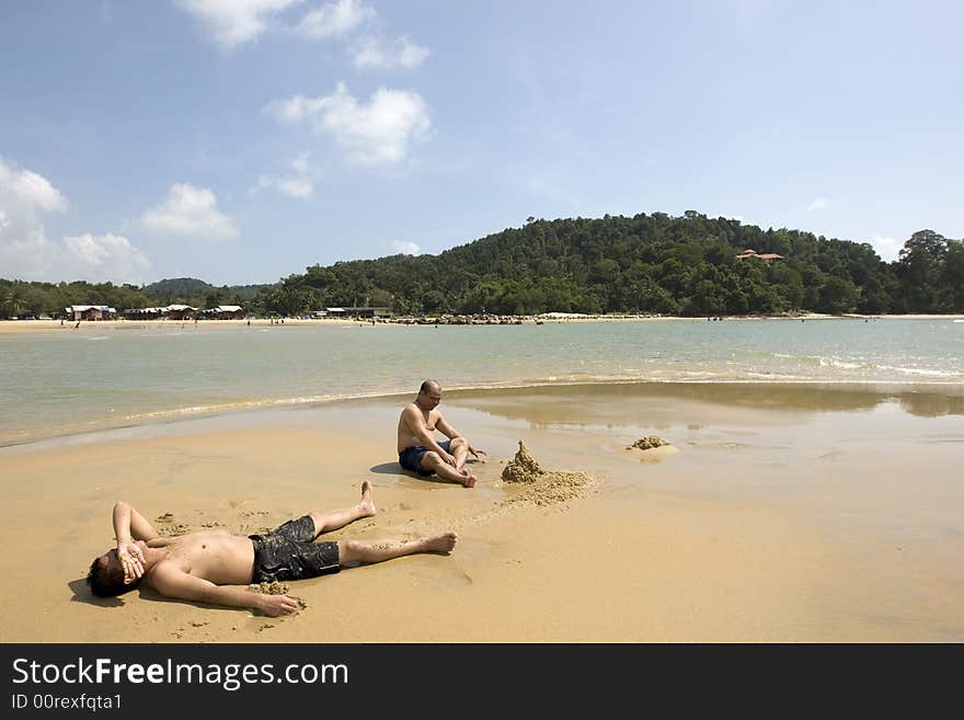 Adults Playing with the Sand on the Beach. Adults Playing with the Sand on the Beach