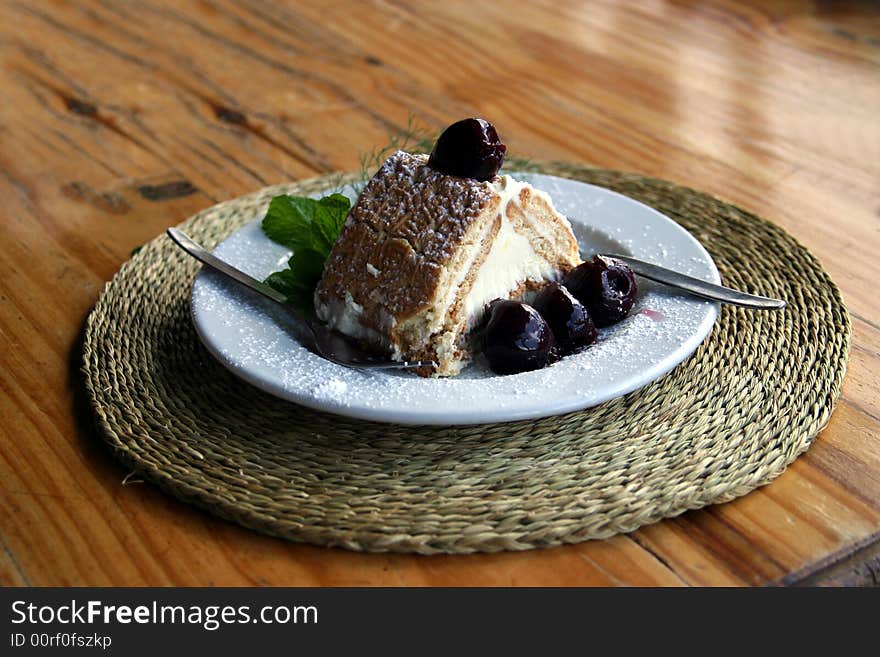 A slice of yummy Cheesecake with cherries on a plate