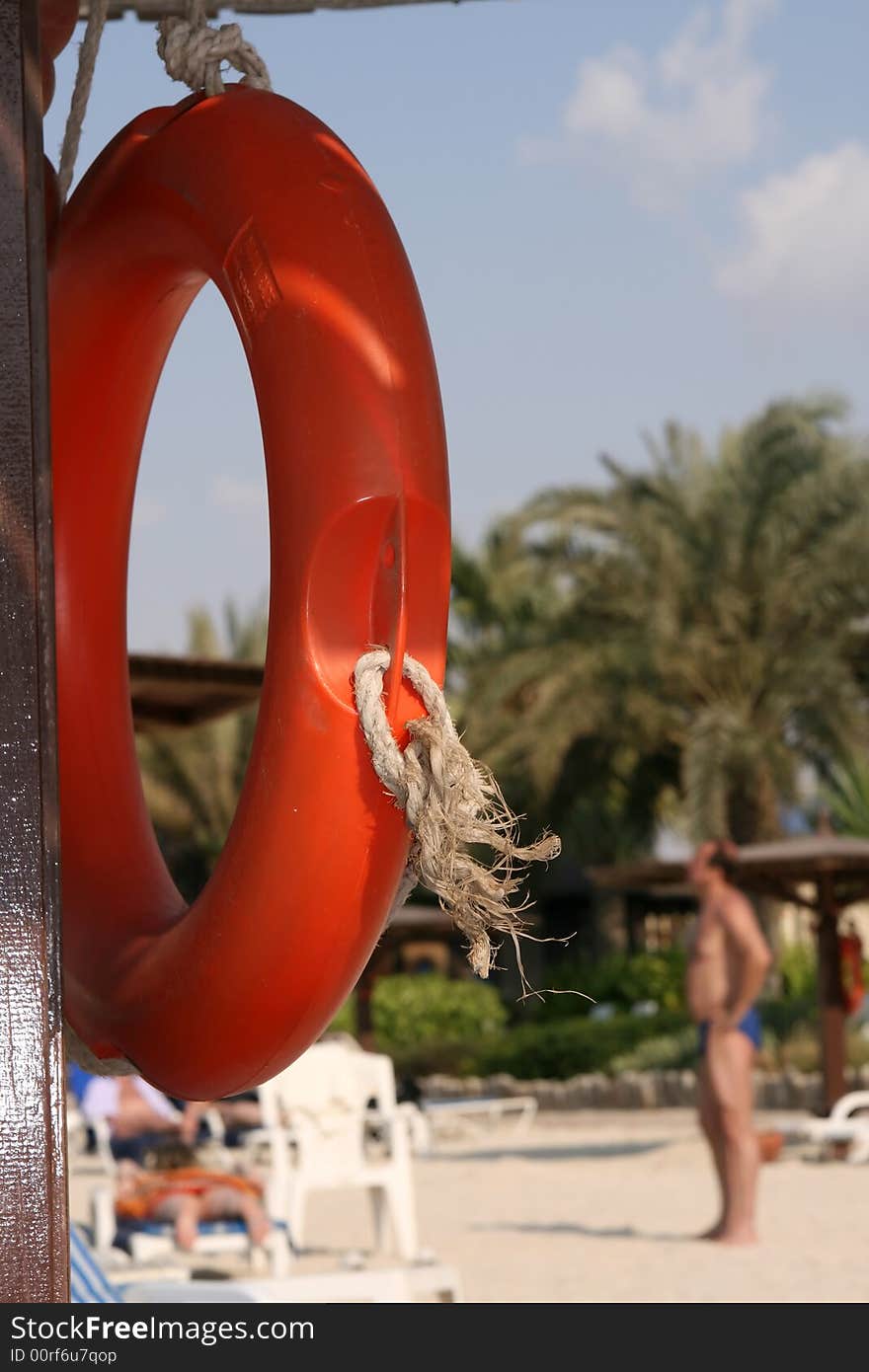 Orange decorative life vest under a beach umbrella