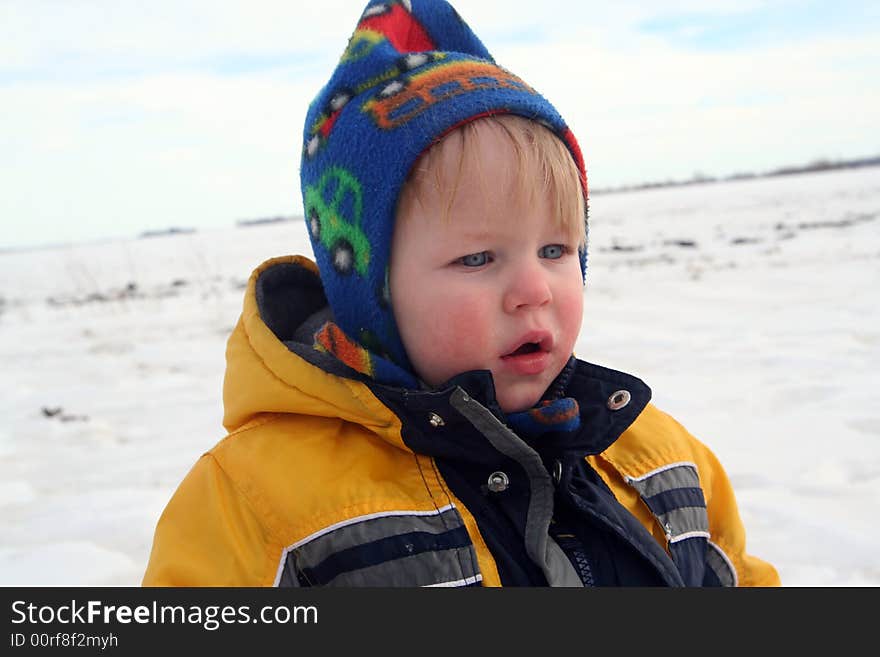 Infant boys first winter, out in snow bundled up in colorful snow gear. Infant boys first winter, out in snow bundled up in colorful snow gear.