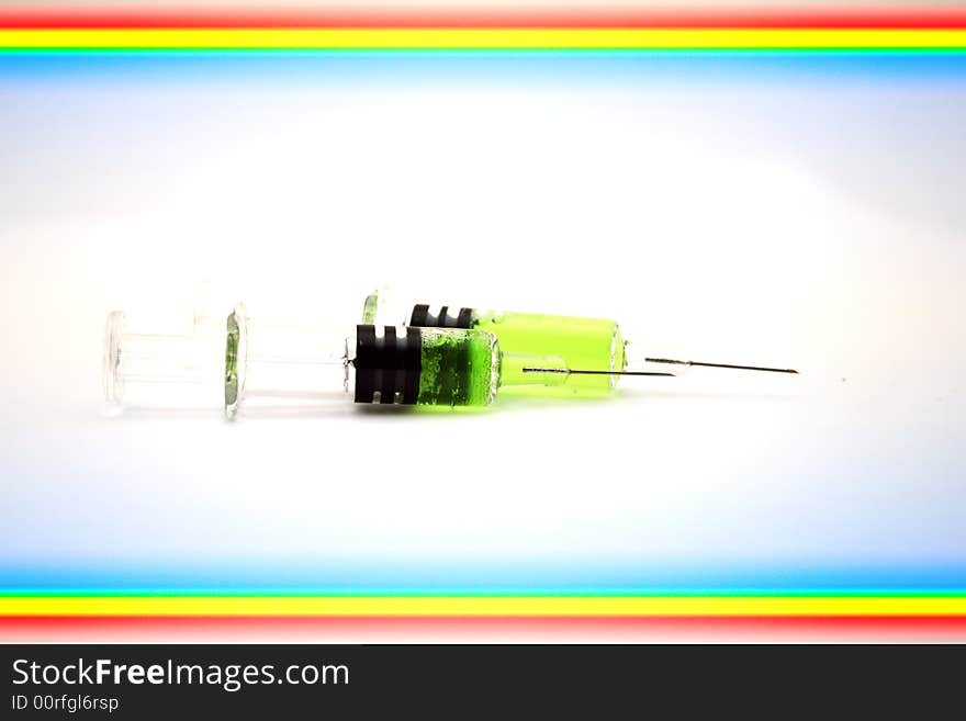 Syringe with green substance incide on white