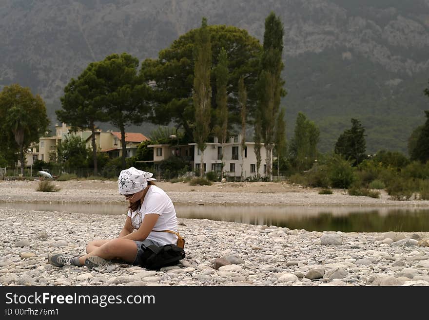 The young girl bored on a sea beach. The young girl bored on a sea beach