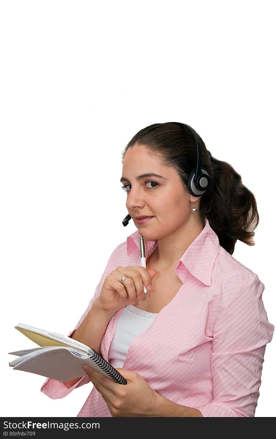 A girl, wearing headphones and microphone, holding a notebook in one and a ball pen in other hand. A girl, wearing headphones and microphone, holding a notebook in one and a ball pen in other hand