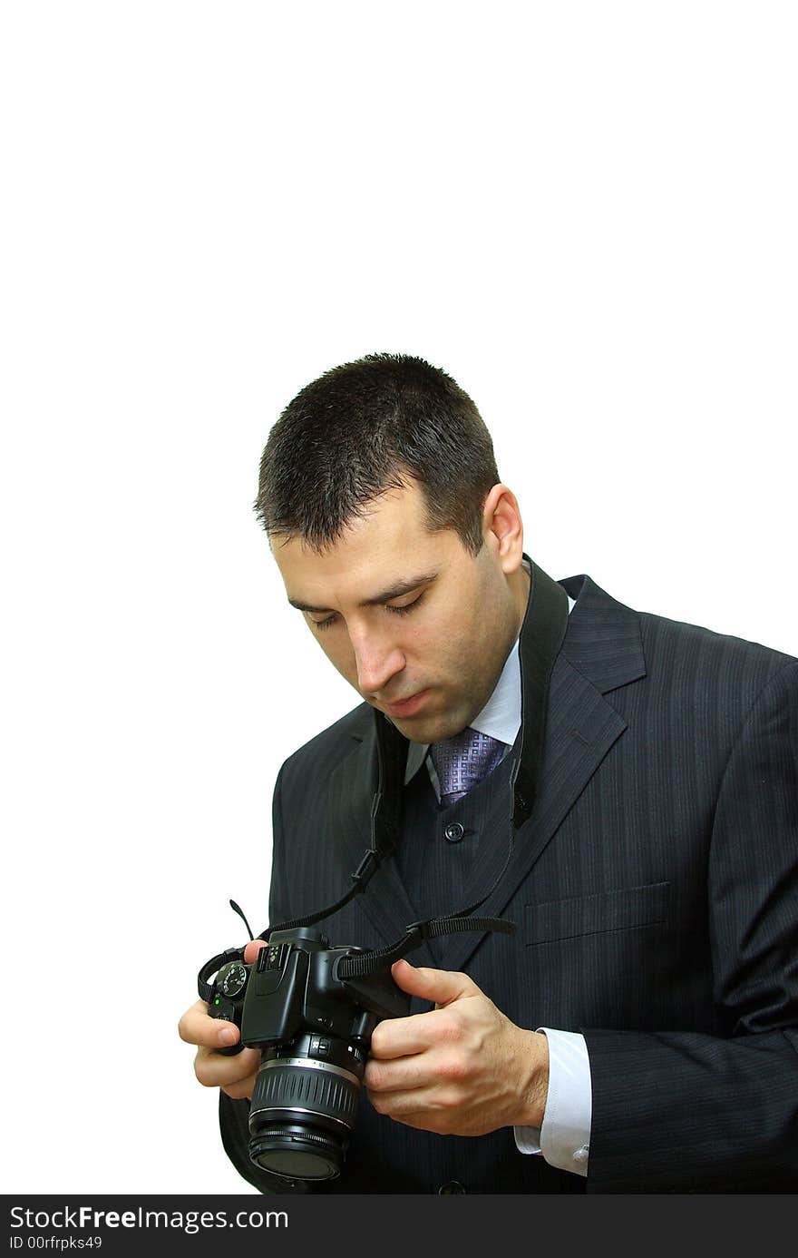 A man, wearing a suit, holding a camera, getting familiar with its functions. A man, wearing a suit, holding a camera, getting familiar with its functions